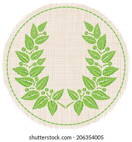 Embroidered "satin stitch" laurel wreath on a round piece of cloth