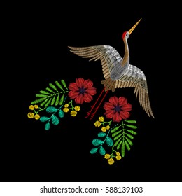 Embroidery with Asian crane, spring wildflowers for decor. Vector fashion embroidered ornament on black background for textile, fabric traditional folk decoration