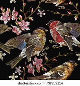Embroidery birds and blossoming cherry seamless pattern. Classical embroidery bullfinch and titmouse on branch blossoming sakura. Spring fashion pattern template for design of clothes, t-shirt design