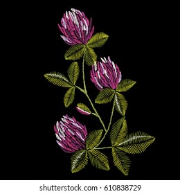 Embroidery colorful ethnic floral design with clover. Vector flowers ornament on black background for fashion design	