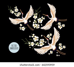 Embroidery colorful floral pattern with flowers, japanese white crane. Vector traditional folk fashion ornament on black background.