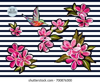 Embroidery colorful floral pattern with  japanese flowers, sakura, hummingbird. Vector traditional folk fashion ornament on black background.