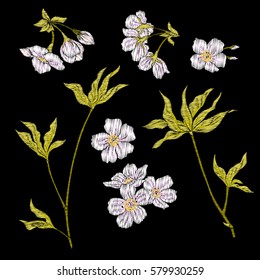 Embroidery. Embroidered design elements with sakura flowers and leaves in vintage style on a black background. Stock vector illustration.