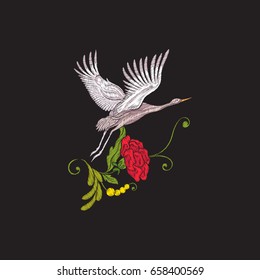 Embroidery flowers and crane on black background. 