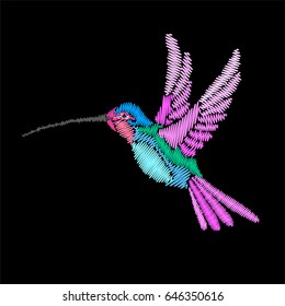 Embroidery flying bird. Bright hummingbird isolated on black background.