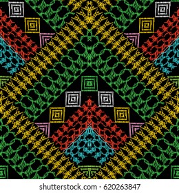 Embroidery geometric seamless pattern. Black  background with colorful tribal  tapestry ornaments, geometrical abstract shapes, rhombus, squares. Vector bright grunge texture in aztec stile.
