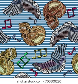 Embroidery human skull, angel wings and music notes seamless pattern background of in blue stripes. Rock pattern skull embroidery, hand drawn fashion template for clothes, textiles, t-shirt design