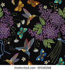 Embroidery lilac tropical humming birds, butterflies seamless pattern. Violet blossoming lilac, birds, embroidery seamless background. Fashionable template for design of clothes, t-shirt design 