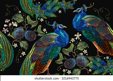 Embroidery peacocks tropical birds and plum branch seamless pattern. Classical fashionable embroidery beautiful peacocks. Fashionable template for design of clothes 