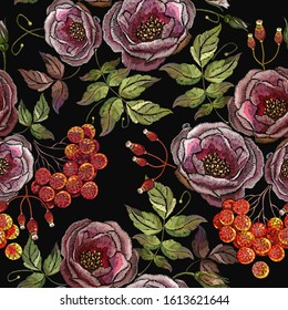 Embroidery red branches of a mountain ash berry and wild roses flowers seamless pattern. Fashionable template for design of clothes 