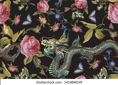 Embroidery seamless floral pattern with green dragons, roses and butterflies. Vector traditional embroidered bouquet with flowers on black background for clothing design.