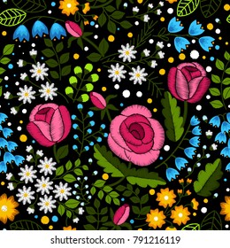 Embroidery seamless pattern with beautiful wildflowers and roses on black background. Flower embroidery for fashion textile and fabric. Satin stitch imitation, vector. Trend floral pattern for design.