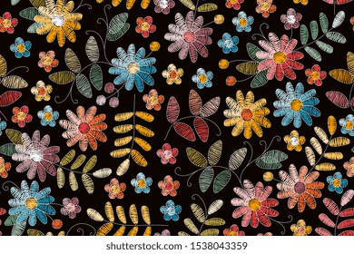 Embroidery seamless pattern with colorful flowers and leaves on black background. Beautiful print for fabric. Embroidered floral design.