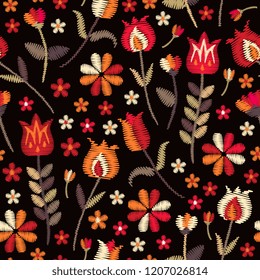 Embroidery seamless pattern in folk style. Stylized flowers on black background. Vector embroidered print for fabric in ethnic style.