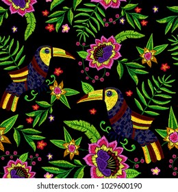 Embroidery tropical seamless pattern with exotic flowers and toucans. Vector embroidered floral illustration with bird for clothing design.