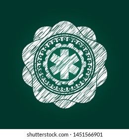 emergency cross icon inside chalk emblem written on a blackboard