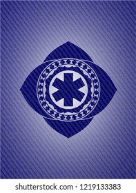 emergency cross icon inside emblem with jean background