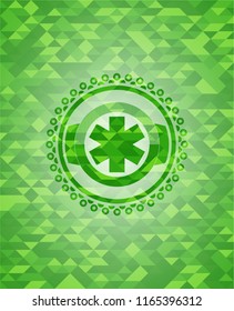 emergency cross icon inside green emblem with mosaic background