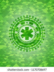 emergency cross icon inside green emblem with triangle mosaic background