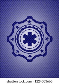 emergency cross icon inside jean or denim emblem or badge background