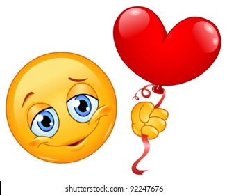 Emoticon holding a heart shape balloon