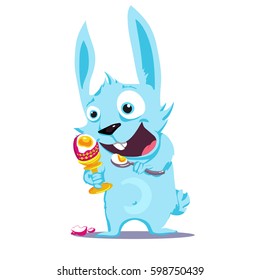 Emotional blue rabbit eats an easter egg with a spoon stand