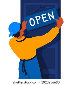 An employee of a store or restaurant hangs a sign open. Opening, reopening stores, shops, businesses. A retail worker, a waiter holds a signboard.