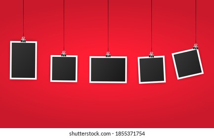 An empty photo frame set hanging on a clip. Black blank space for text or photo. Realistic photo icon design template. Vector on isolated background. EPS 10