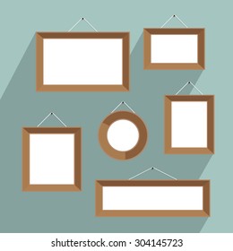 Empty picture frames for your design. Wooden frame hanging on nails on the blue wall.