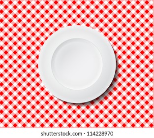 Empty plate on a red checked tablecloth ideal for placing in the background of your design. Picnic planer or food diet chart.