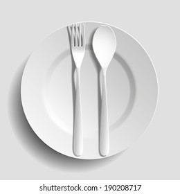 Empty plate with spoon and fork on a white background.