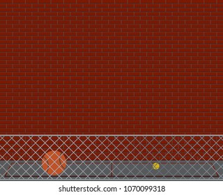 An empty school yard with a wall, fence and balls