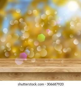Empty table of light brown wooden planks on autumn background with sun and glares