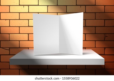 An empty white greeting card is standing on a shelf near a red brick wall. Light from the window creates oblique shadows. Mockup for design