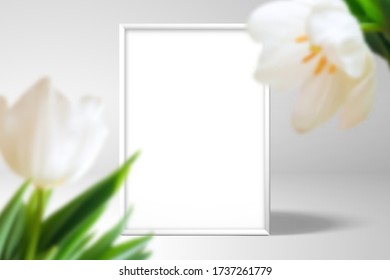 Empty white picture frame. In the foreground are large tulip flowers. Realistic template for spring romantic or wedding design	
