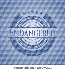 Endangered blue emblem or badge with abstract geometric pattern background.