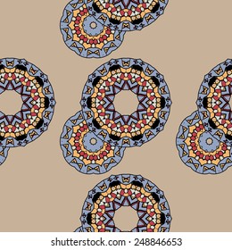 Endless ornate pattern made of indian mandalas over brown background, copyspace in the corner.