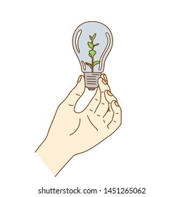 Energy saving concept, hand holding plant growing in electric light bulb.