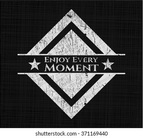Enjoy Every Moment chalkboard emblem written on a blackboard