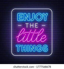 Enjoy the little things neon inspirational quote on a brick wall background.