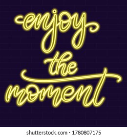 Enjoy the moment Neon sign calligraphic lettering vector illustration with calligraphy style word. Handwritten text for fabric print, logo, poster, card. Light banner, glowing neon signboard.