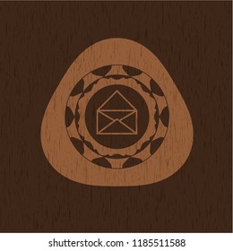 envelope icon inside badge with wood background