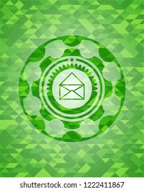 envelope icon inside green emblem with triangle mosaic background