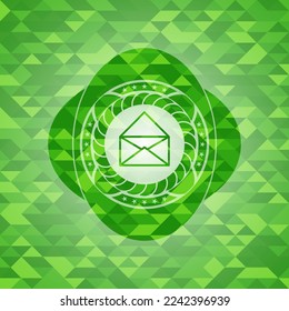 envelope icon inside green emblem with mosaic ecological style background. 