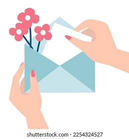 An envelope with a message and flowers in women's hands, girl opens a gift envelope, birthday, women's day or mother's day concept