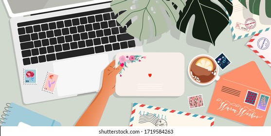 Envelopes, laptop and post cards on the table. Hands holding an envelope. Top down view. Greeting card and a letter in a hand. Modern vector illustration for web design and print. 