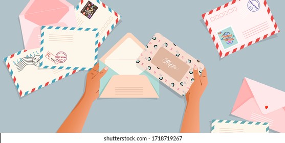Envelopes and post cards on the table. Hands holding an envelope. Top down view. Greeting card and a letter in a hand. Modern vector illustration for web design and print. Retro cards and envelopes.