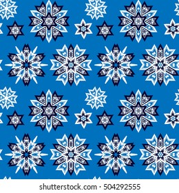 Ethnic Christmas seamless blue pattern. Boho textile print. New Year wallpaper. Winter decorative background with snowflakes.