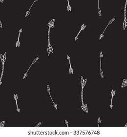 Ethnic seamless pattern. Texture with tribal hand drawn arrows. Native american design. Backdrop with vintage arrows. White doodle elements on the black background. Vector illustration.