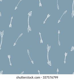 Ethnic seamless pattern. Texture with tribal hand drawn arrows. Native american design. Backdrop with vintage arrows. White doodle elements on the blue background. Vector illustration.